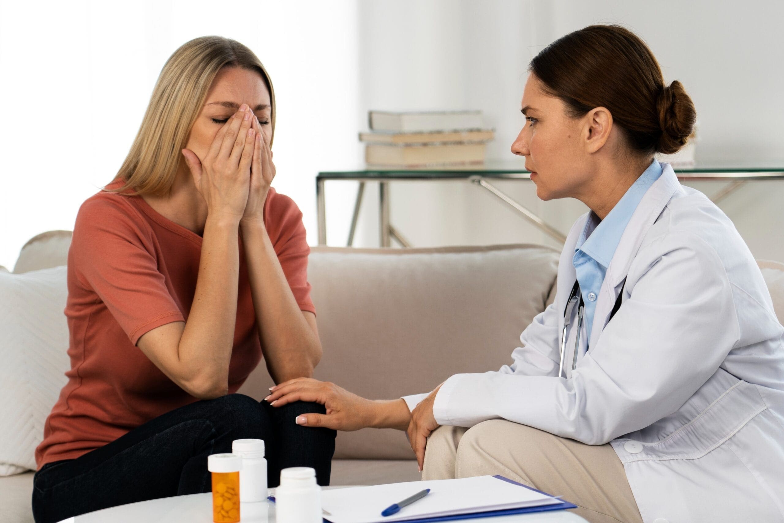 A healthcare provider consoling a distressed patient while discussing the process of prior authorization for Venlafaxine HCL ER 37.5mg tablets with WellCare Medicare.