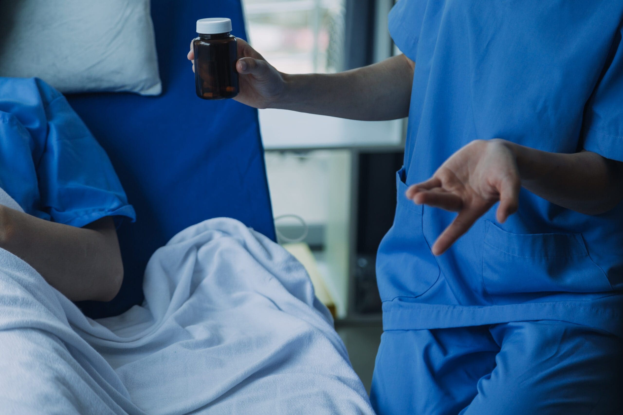 Healthcare provider holding a medication bottle while discussing Temazepam use for insomnia management with a patient.