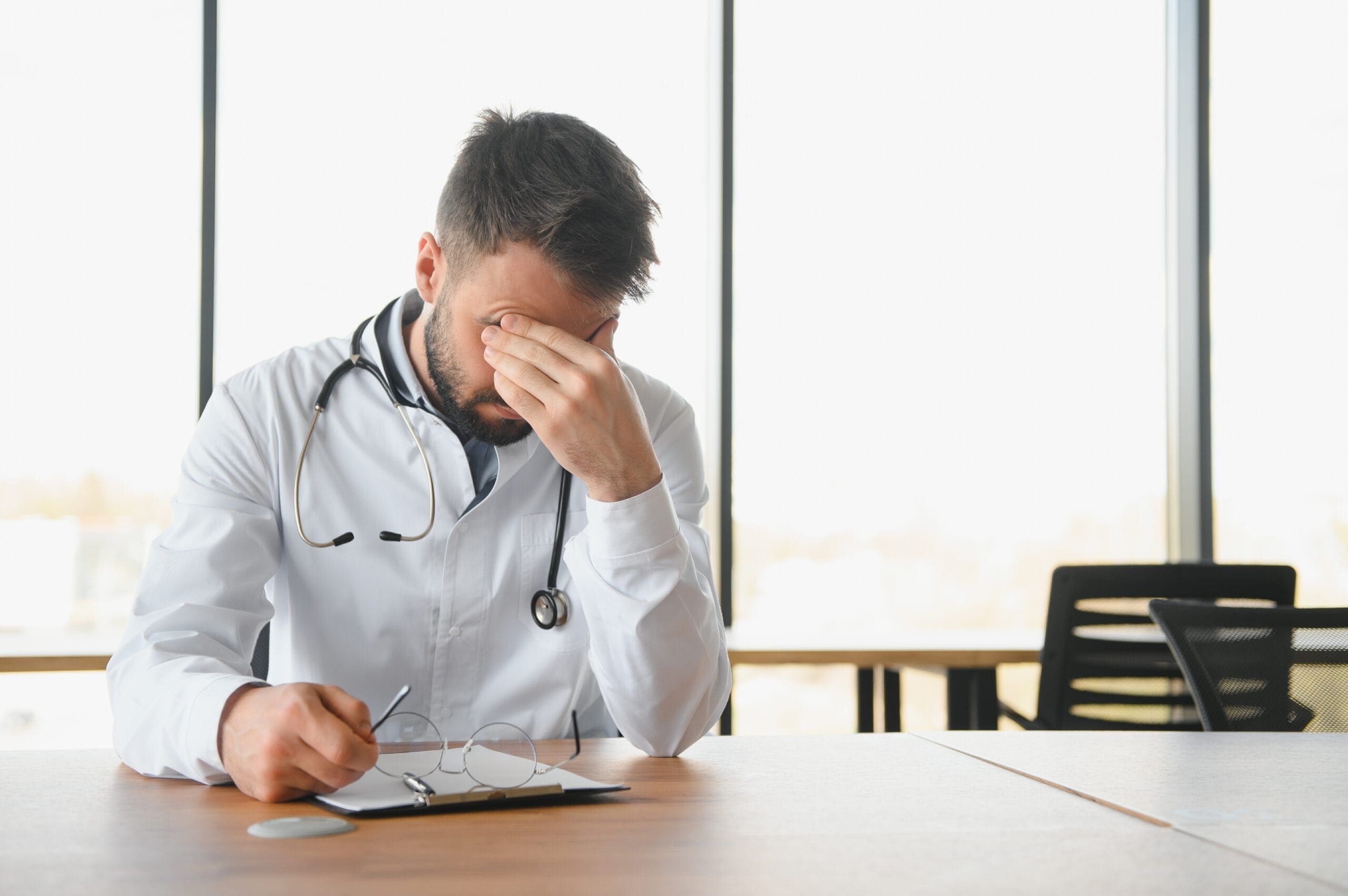 Stressed healthcare provider reviewing documents, representing the challenges of managing prior authorization requests for medications like Fluoxetine