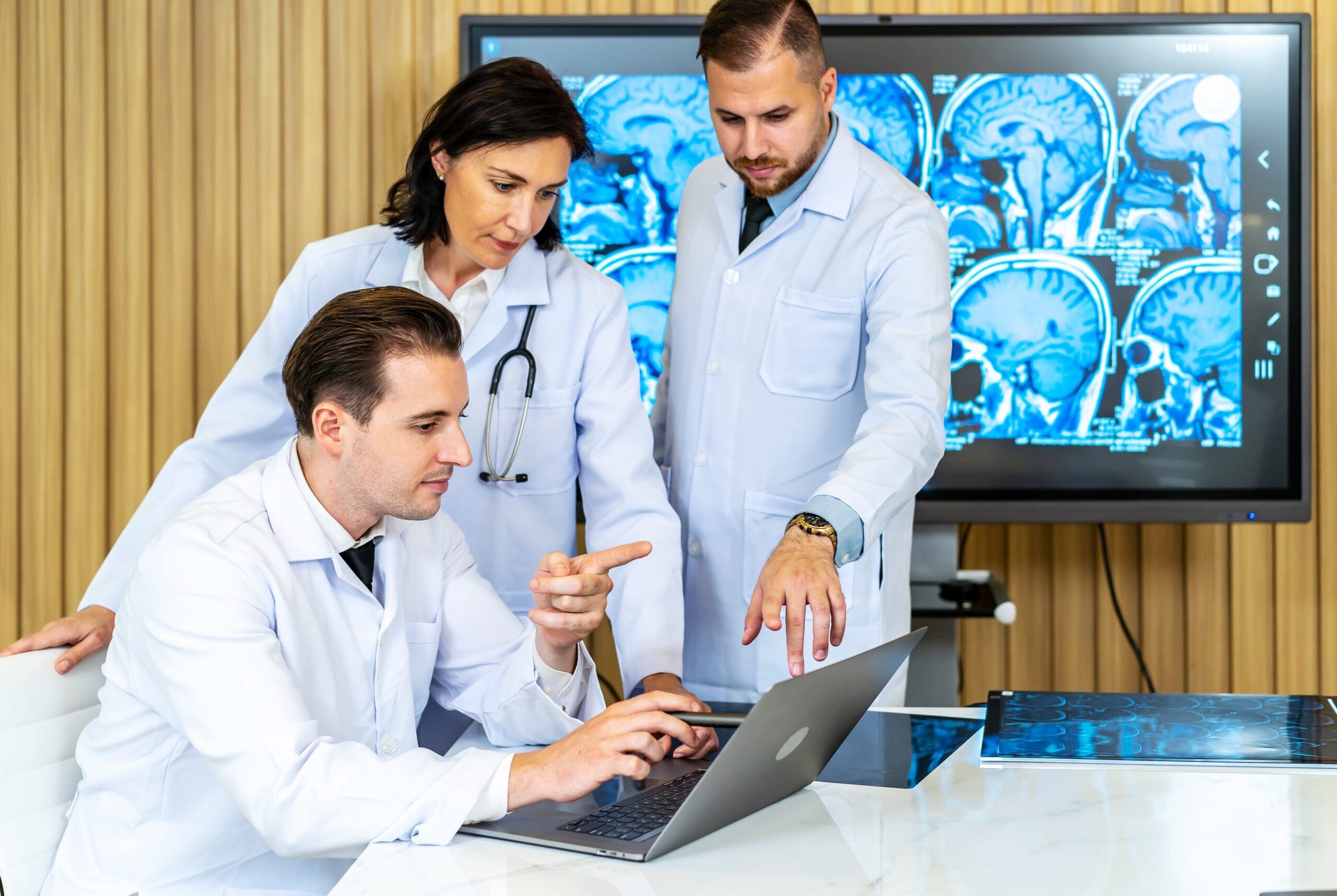 Healthcare providers reviewing patient documentation on a laptop for prior authorization of OxyContin ER
