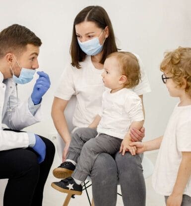 A healthcare provider interacting with a mother and two young children in a clinical setting, highlighting a supportive and family-friendly healthcare environment. The provider is engaged in explaining treatment options, fostering trust and communication with the patients.