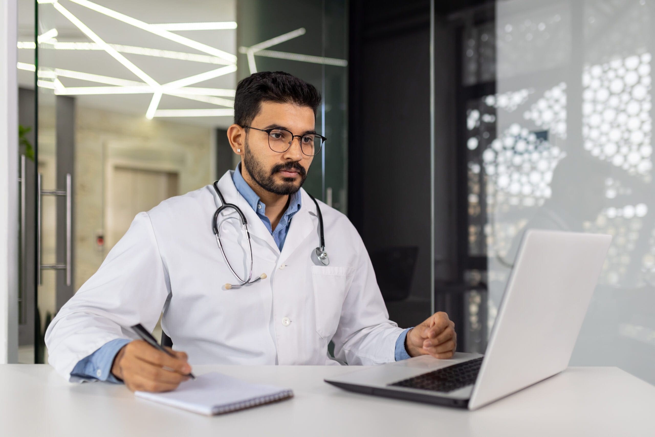 Doctor reviewing patient records on a laptop for Medicare prior authorization of Submittedin for GERD treatment.