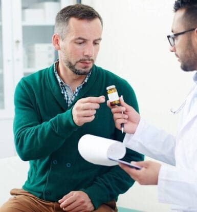 A doctor explaining medication requirements to a patient, helping him understand the process for prior authorization under Medicare for a prescribed medication.