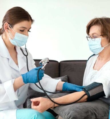 Healthcare provider checking blood pressure of an older female patient during a consultation about prior authorization for medications like Vascepa.