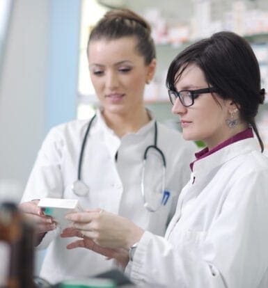 A healthcare professional working on billing software with documents and charts in the background