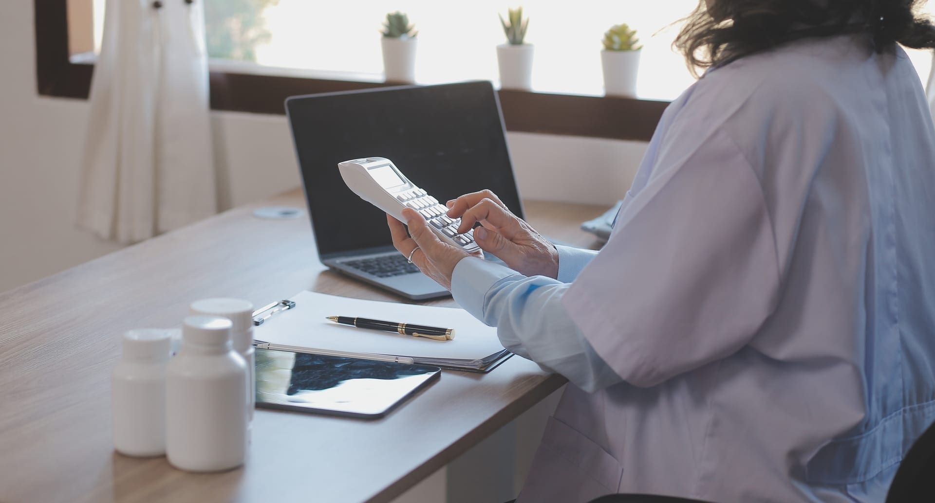 A medical scribe documenting patient information alongside a physician in a clinical setting.