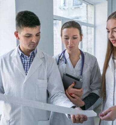 Healthcare professional using digital tablet to explore healthcare outsourcing solutions like virtual assistants and medical billing.