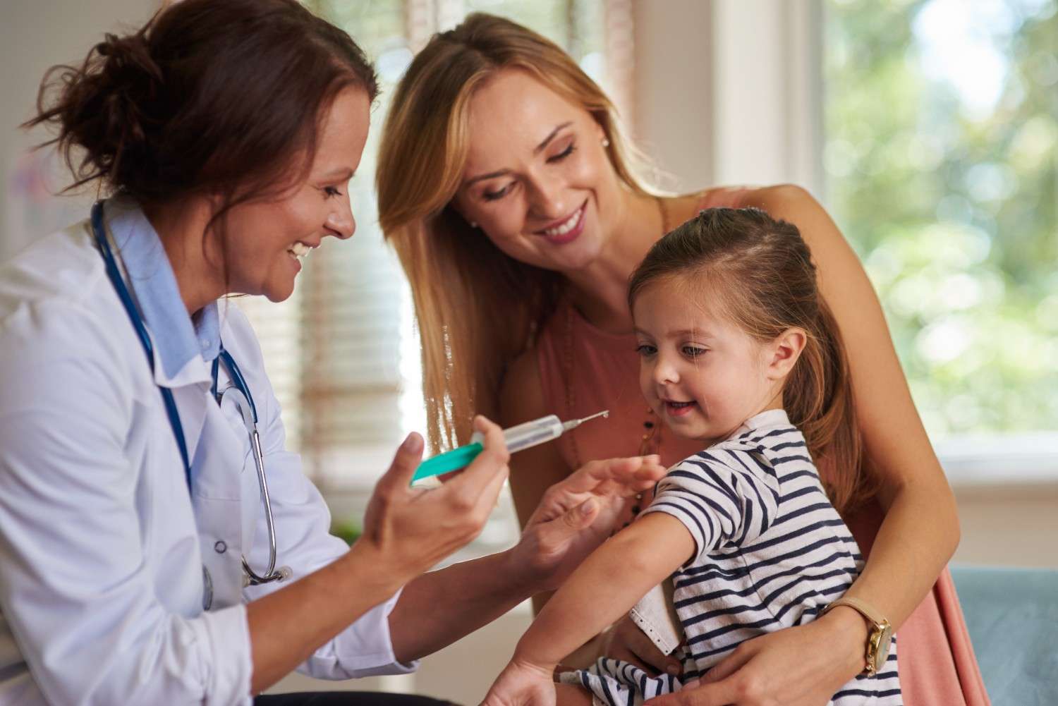 Doctor giving a child an injection with her mother smiling beside her, representing the process of obtaining prior authorization for Dupixent 200 mg.