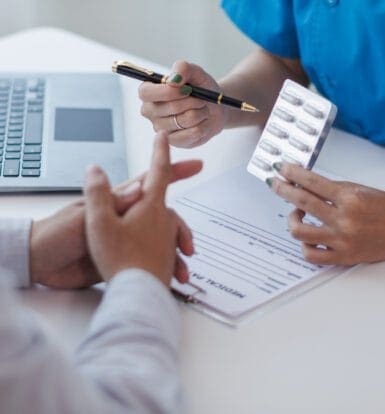 A healthcare professional working on a computer to process prior authorizations.