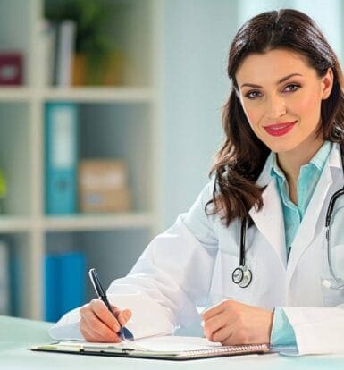 : A Florida doctor interacting with a patient while a medical scribe updates electronic health records.