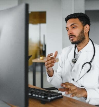 Doctor using a computer for a virtual medical assistant consultation.